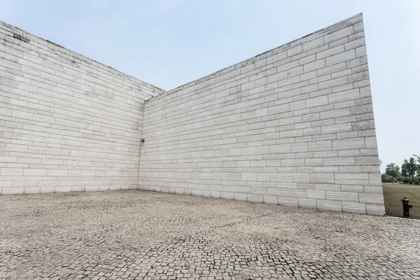 Mur de briques blanches et route de grès vide — Photo