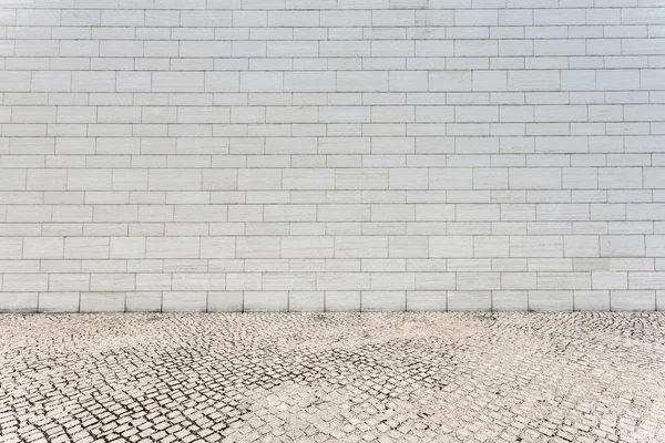 Mur de briques blanches et route de grès vide — Photo