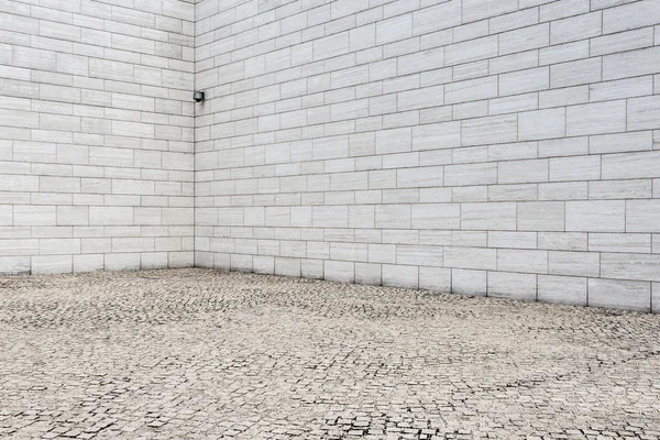 Witte bakstenen muur en lege zandsteen weg — Stockfoto