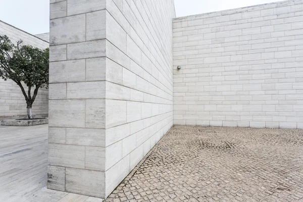 Mur de briques blanches et route de grès vide — Photo