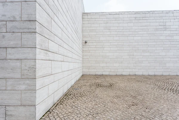 Mur de briques blanches et route de grès vide — Photo