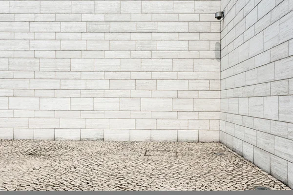 Witte bakstenen muur en lege zandsteen weg — Stockfoto