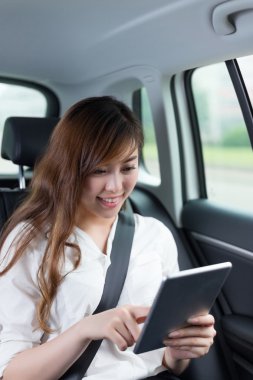 Asyalı kadın arabada dijital tablet kullanma