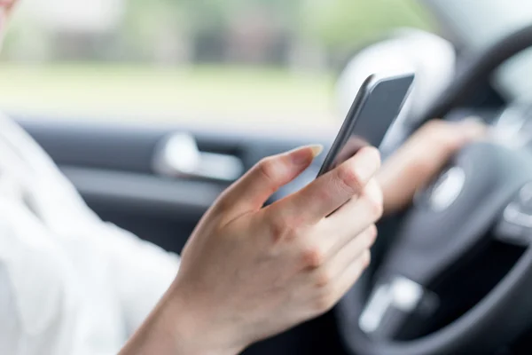 Mujer usando el teléfono móvil y coche de conducción — Foto de Stock