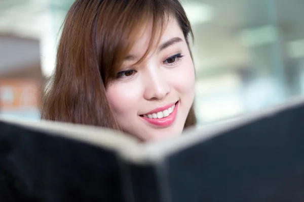 Aziatische vrouwelijke student leesboek — Stockfoto