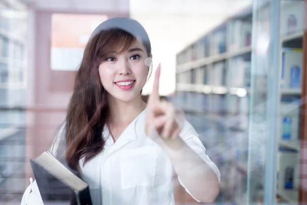 Kız öğrenci Kitaplığı'nda cam ekran dokunaklı — Stok fotoğraf