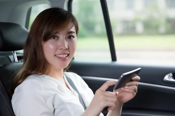 자동차에 휴대 전화를 사용 하 여 아시아 여자 — 스톡 사진