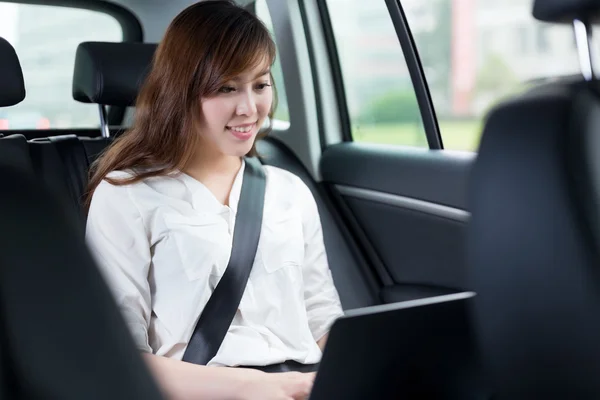 Mulher asiática usando laptop no carro — Fotografia de Stock