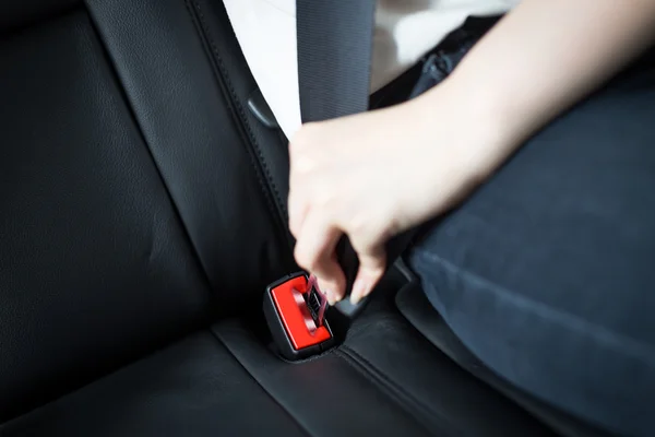 Beifahrer schnallt sich im Auto an — Stockfoto