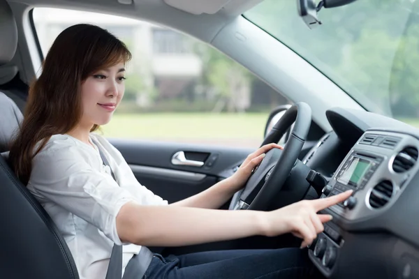 Asiático feminino motorista tocando painel no carro — Fotografia de Stock