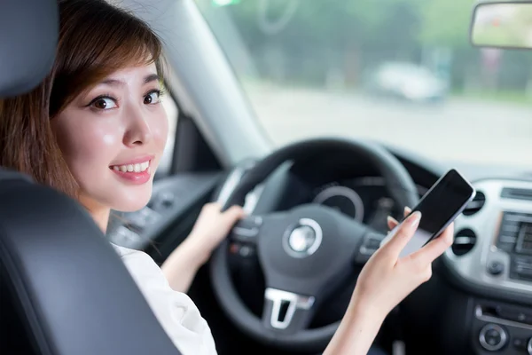 Mulher usando telefone celular e carro de condução — Fotografia de Stock