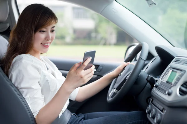 핸드폰을 사용하고 운전하는 여성 — 스톡 사진