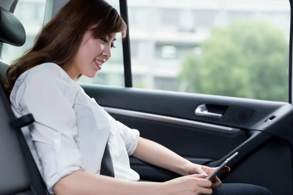 Mulher asiática usando tablet digital no carro — Fotografia de Stock