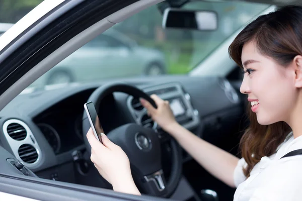 Mulher usando telefone celular e carro de condução — Fotografia de Stock