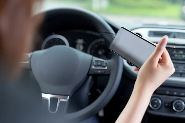 Mulher usando telefone celular e carro de condução — Fotografia de Stock