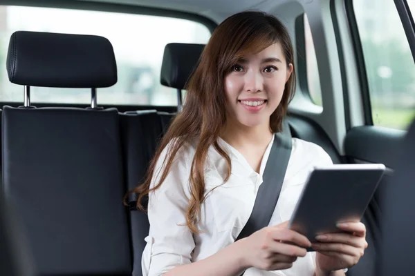 Mulher asiática usando tablet digital no carro — Fotografia de Stock