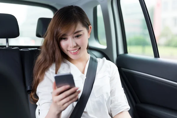 Mulher asiática usando telefone celular no carro — Fotografia de Stock