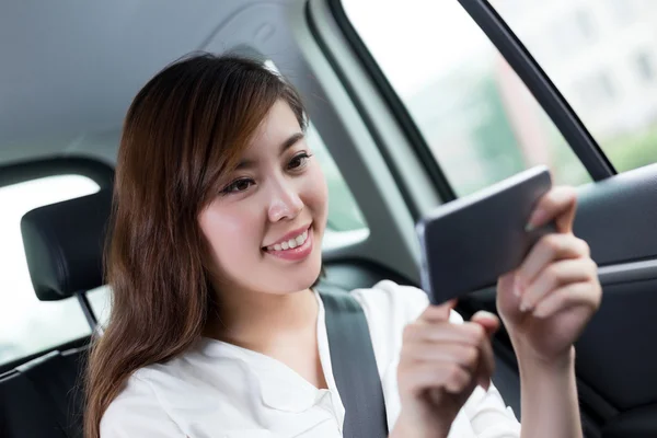 자동차에 휴대 전화를 사용 하 여 아시아 여자 — 스톡 사진