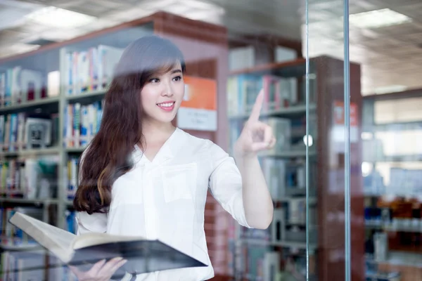 Φοιτήτριας αγγίζοντας την οθόνη γυαλιού στη βιβλιοθήκη — Φωτογραφία Αρχείου