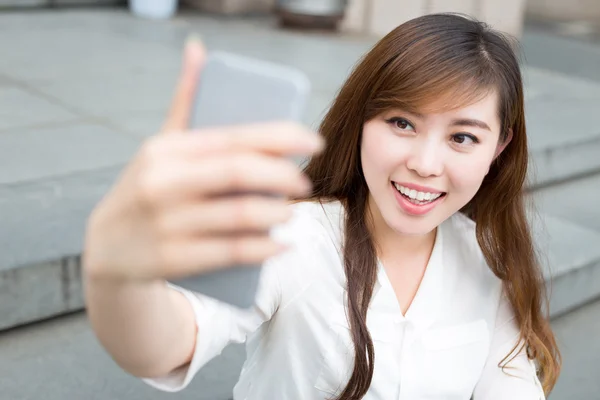 Mujer usando el teléfono móvil para tomar selfie —  Fotos de Stock