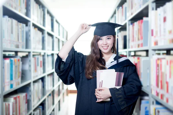 Asiática estudiante sosteniendo libros en la biblioteca —  Fotos de Stock