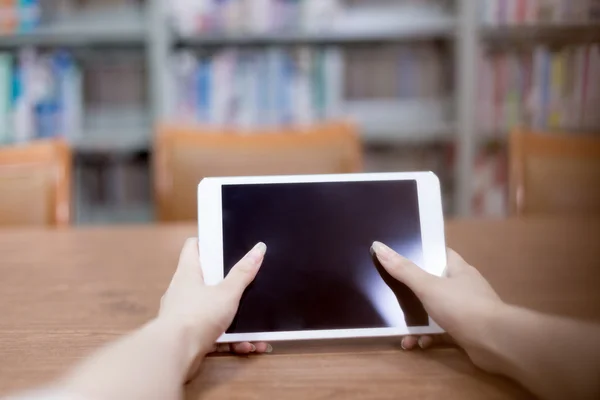 Mulher mãos tocando tablet na biblioteca — Fotografia de Stock