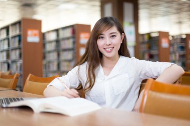 Asyalı kız öğrenci dizüstü Kitaplığı'nda kullanma
