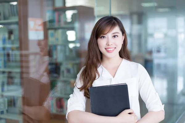 Asiatico femmina studente holding libro in biblioteca — Foto Stock
