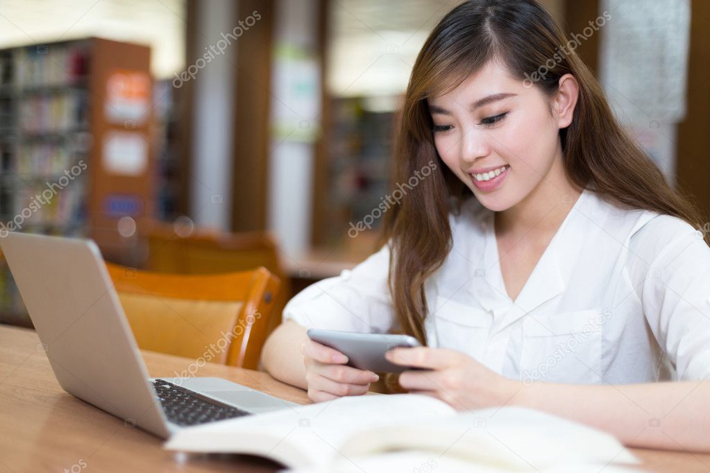 female student studying in library with laptop