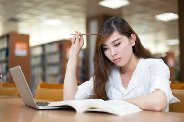 Ženské student studuje v knihovně s notebookem — Stock fotografie