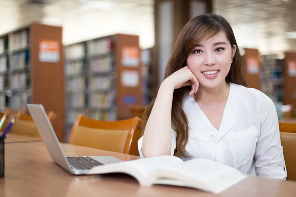 Estudante asiática usando laptop na biblioteca — Fotografia de Stock