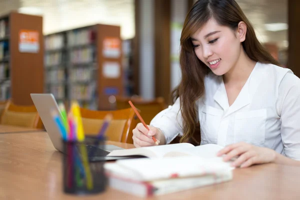 Étudiante étudiant à la bibliothèque avec ordinateur portable — Photo