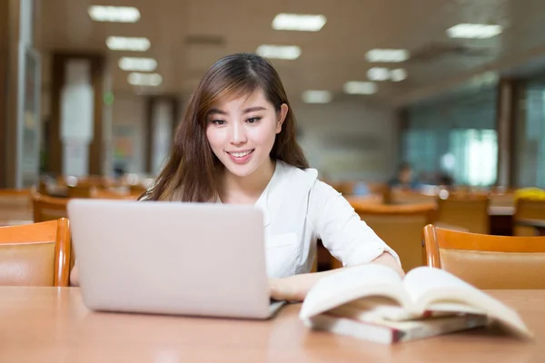 Étudiante étudiant à la bibliothèque avec ordinateur portable — Photo