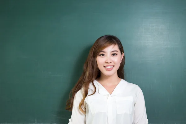 Азиатка перед школьной доской с жестом — стоковое фото