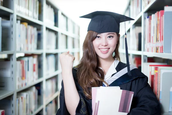 Aziatische vrouwelijke student bedrijf boek in bibliotheek — Stockfoto