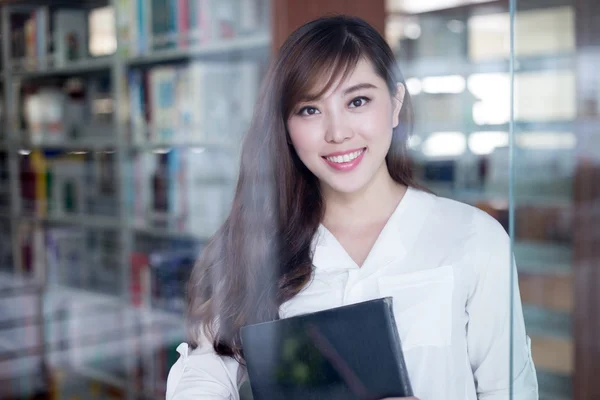 Asiatico femmina studente holding libro in biblioteca — Foto Stock