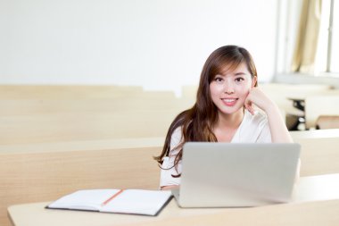 kız öğrencinin sınıf içinde laptop ile eğitim