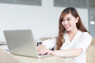 Asyalı güzel kız öğrencinin sınıf içinde laptop ile çalışma