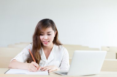 kız öğrencinin sınıf içinde laptop ile eğitim