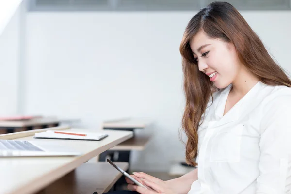 Vrouwelijke student studeert met tablet in de klas — Stockfoto