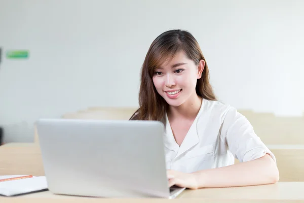 Estudante do sexo feminino estudando com laptop em sala de aula — Fotografia de Stock