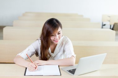 kız öğrencinin sınıf içinde laptop ile eğitim