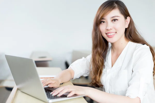 Vrouwelijke student studeert met laptop in de klas — Stockfoto