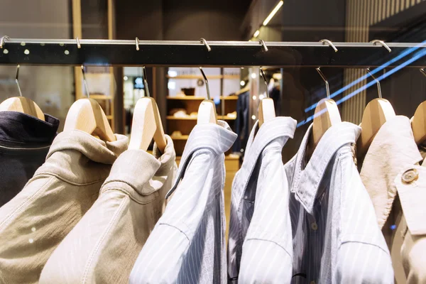 Ropa en percha en la tienda de moda moderna — Foto de Stock