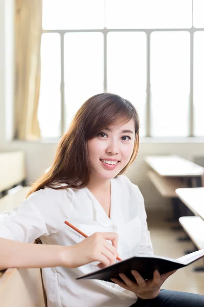 Asiatisk kvinnlig student studerar i klassrummet — Stockfoto