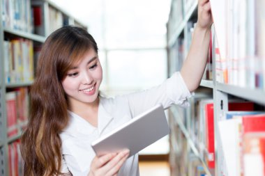 Asyalı kız öğrenci Kitaplığı'nda tablet kullanma