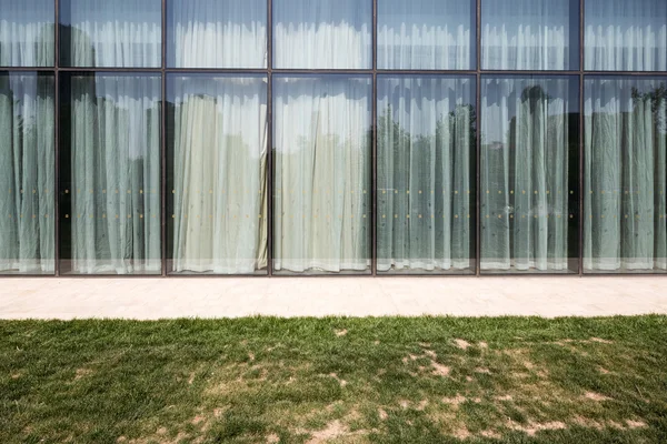 近代的なオフィスのガラス壁と芝生フィールド — ストック写真