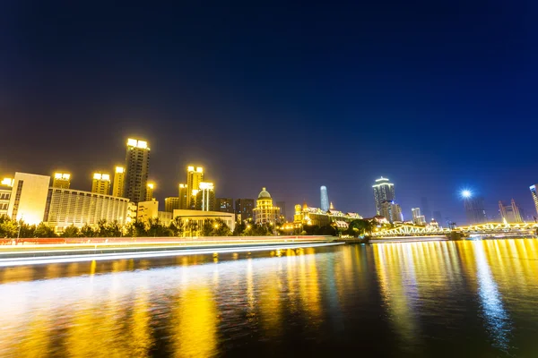 Illuminated skyline and cityscape at riverbank — Stock Photo, Image