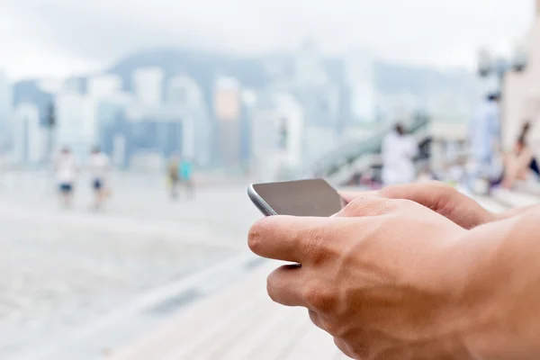 Telefono cellulare in mano sulla strada — Foto Stock