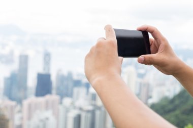 hareket eden telefon ile cityscape arka plan olarak tutan el